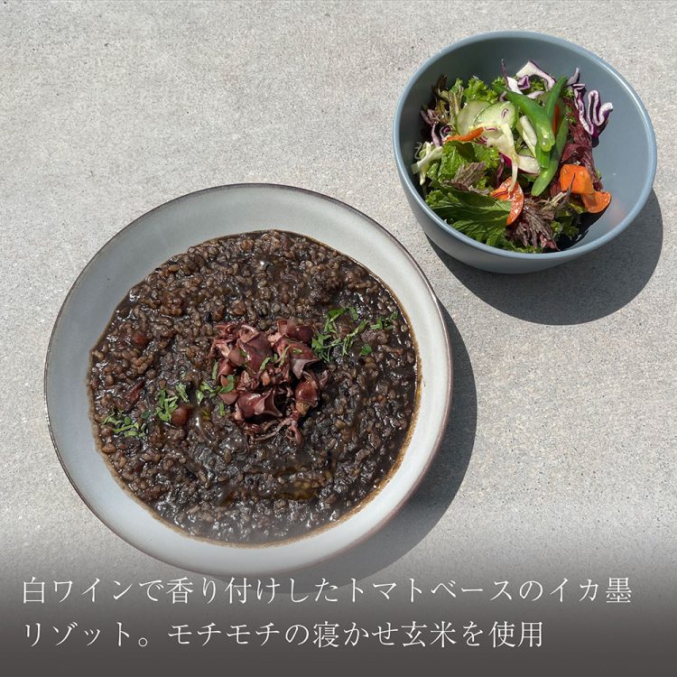 白ワインで香り付けしたトマトベースのイカ墨リゾット。モチモチの寝かせ玄米を使用画像